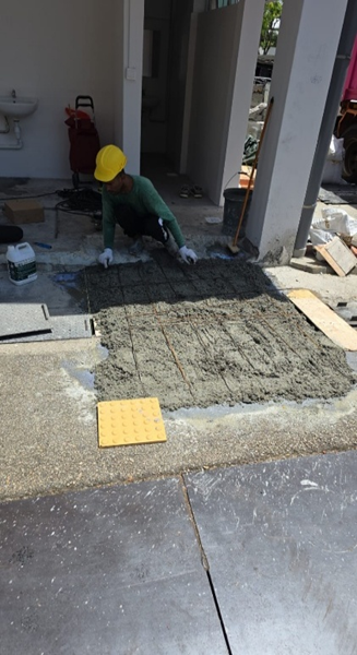Worker laying handicap ramp with tactile paving and concrete screed