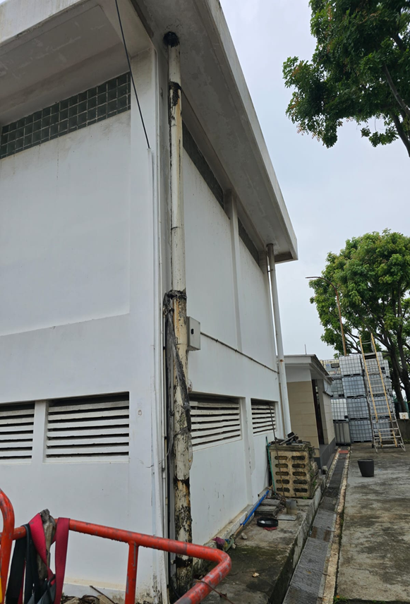 Building facade with new rainwater down pipe installation